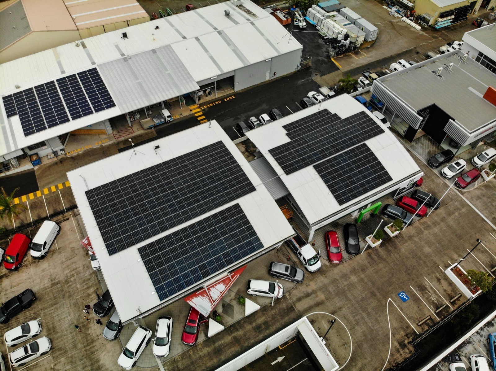 Commercial buildings with large rooftop solar arrays installed across an industrial estate