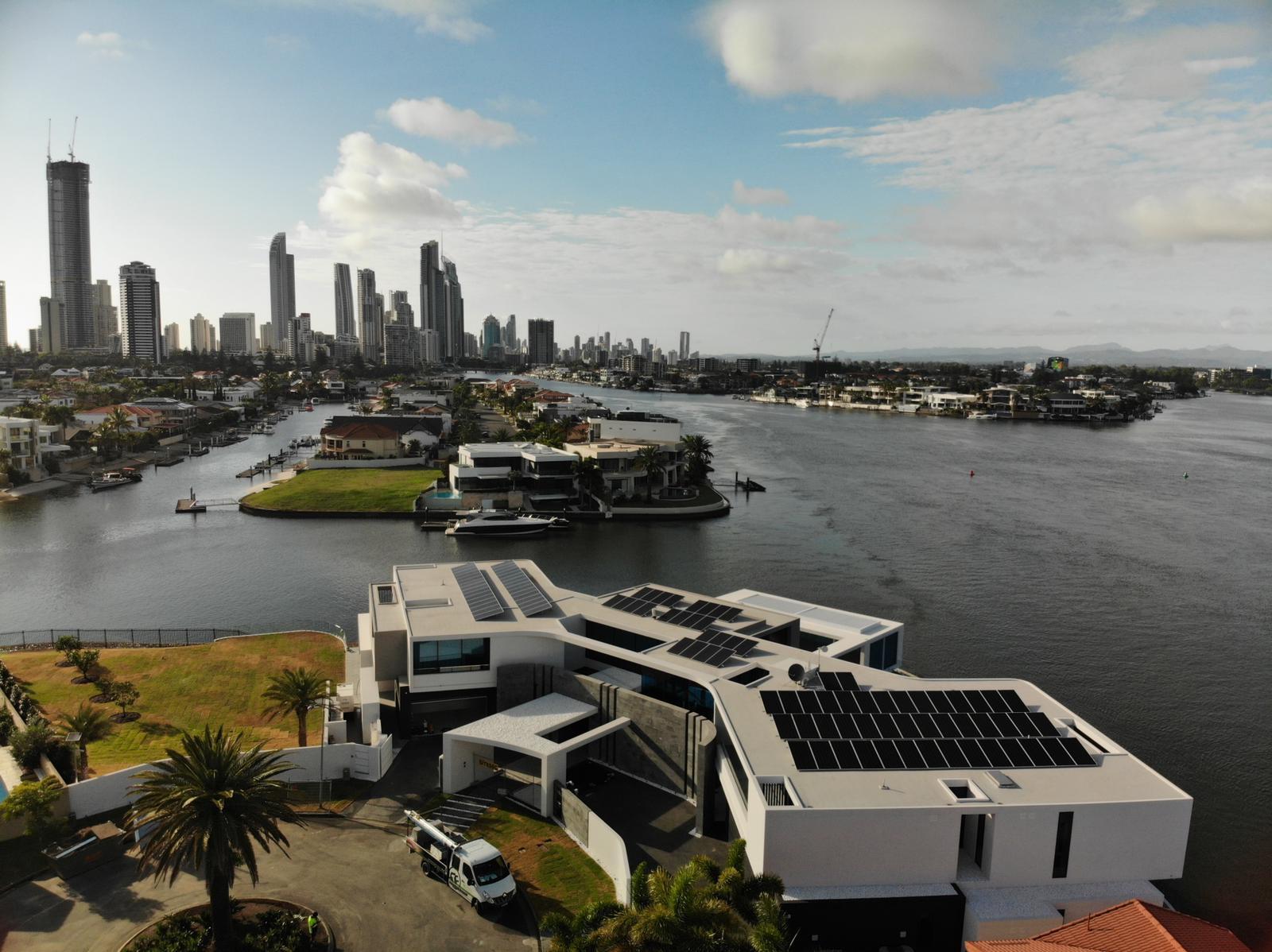 Waterfront home with solar panels installed, Surfers Paradise skyline in the distance