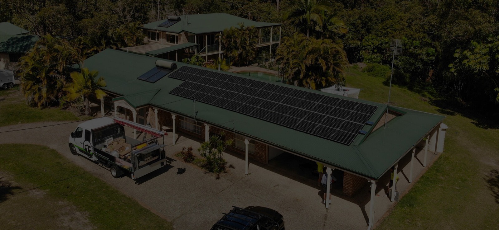 Aerial view of a residential solar installation in progress with a branded Thomas Electrical work vehicle below